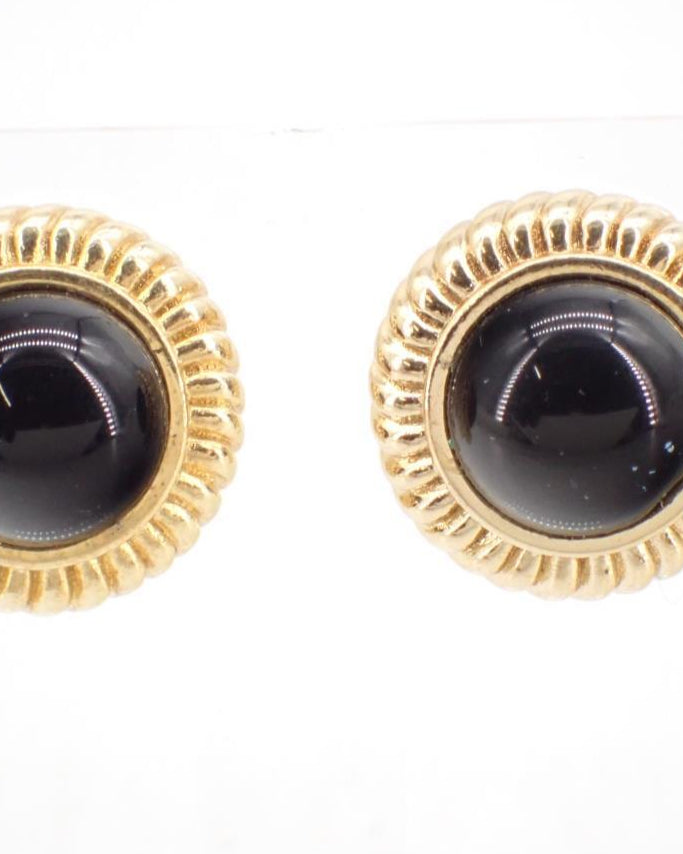 Pair of gold-framed black gemstone earrings on a white background