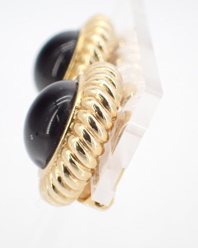 Gold and black earring on a white background