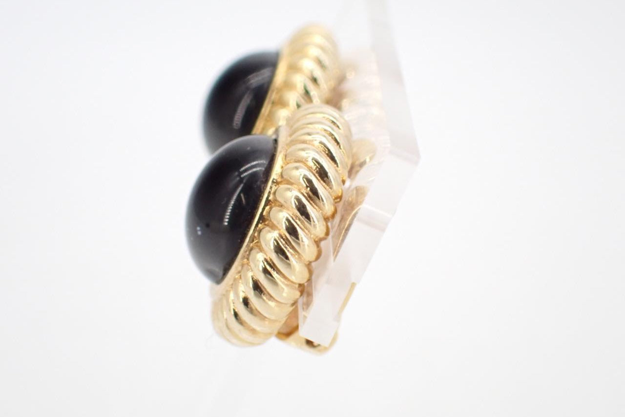 Gold and black earring on a white background