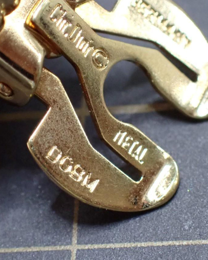 Close-up of a gold clasp on a bracelet with visible branding.