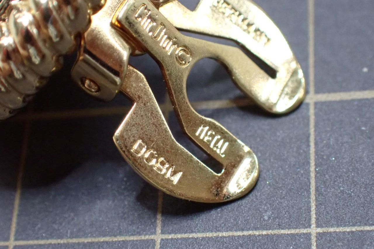 Close-up of a gold clasp on a bracelet with visible branding.