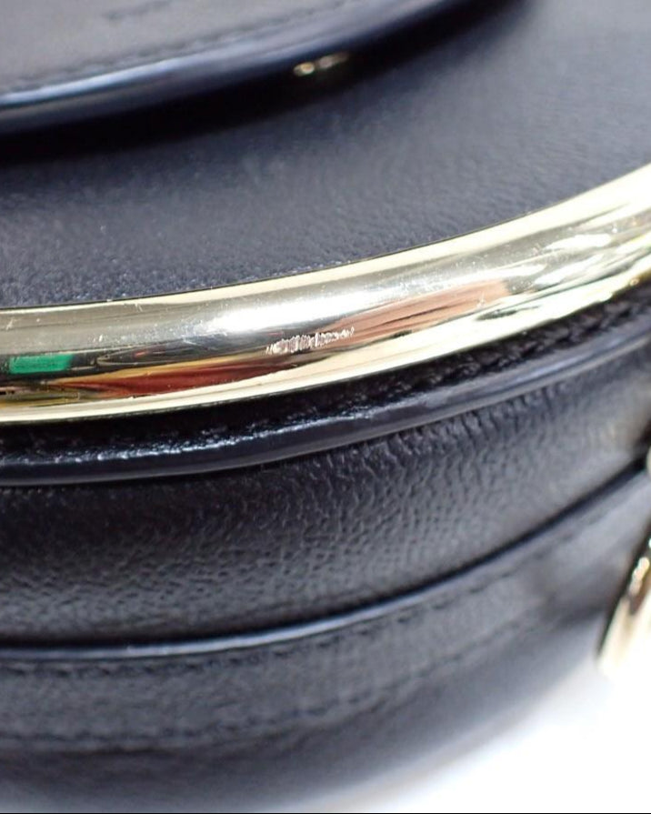 Black handbag with gold chain strap on a white background