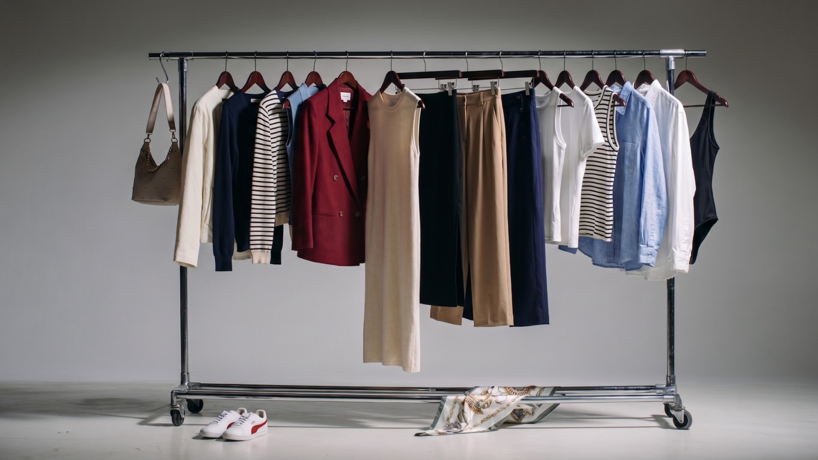 Clothing rack with various garments on a gray background