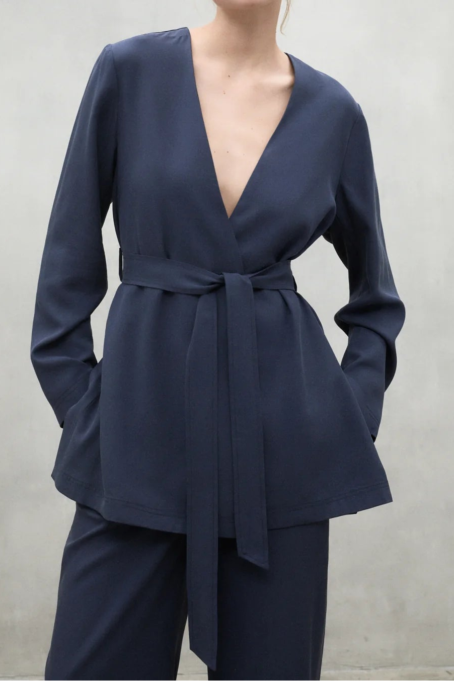 Woman wearing a navy blue outfit against a plain background